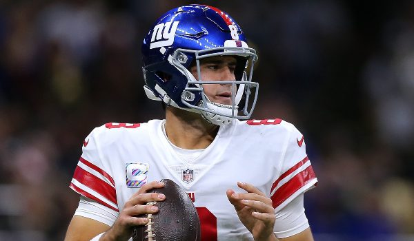 daniel jones, quarterback for the new york giants, in a white jersey as he prepares to throw the ball